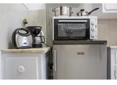 a microwave on top of a refrigerator in a kitchen at Athens view suite in Athens