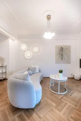 a living room with a blue couch and a table at Stylish acropolis view apartment in Athens