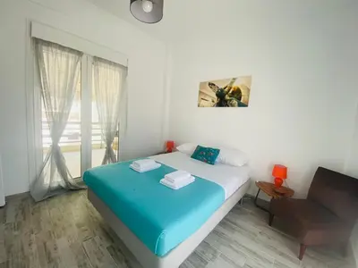 a bedroom with a bed and a chair and a window at Acropolis Penthouse - 100Mbps Internet Connection in Athens