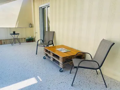 two chairs and a wooden table on a patio at Acropolis Penthouse - 100Mbps Internet Connection in Athens