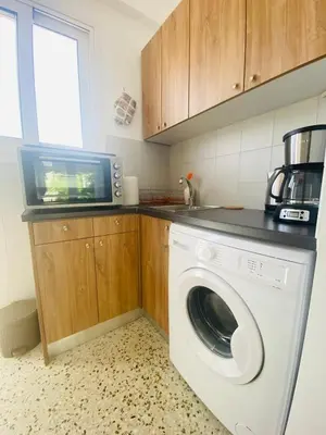 a kitchen with a washing machine and a microwave at Acropolis Penthouse - 100Mbps Internet Connection in Athens