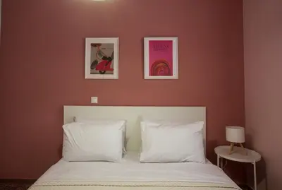a bedroom with a bed with two pictures on the wall at Antigonis Athenian Home in Athens