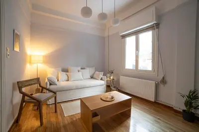 a living room with a white couch and a table at Athens Imperial in Athens