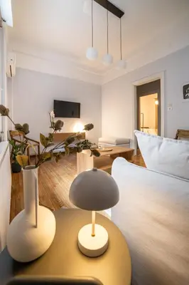 a living room with a bed and a table with a lamp at Athens Imperial in Athens