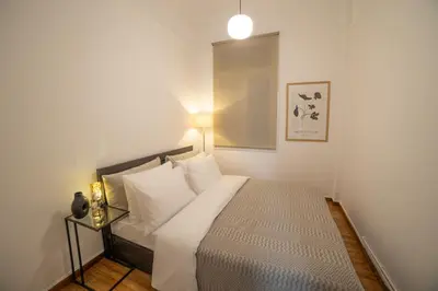 a small bedroom with a bed with white pillows at Athens Imperial in Athens