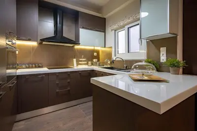a kitchen with brown cabinets and a white counter top at Gkyzi Warm Classic Home by ΜΡS in Athens