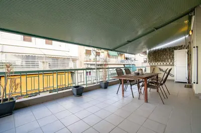 a balcony with a table and chairs on a building at Gkyzi Warm Classic Home by ΜΡS in Athens