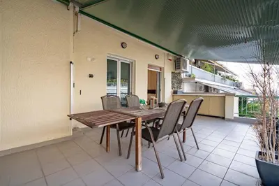 a wooden table and chairs on a patio at Gkyzi Warm Classic Home by ΜΡS in Athens