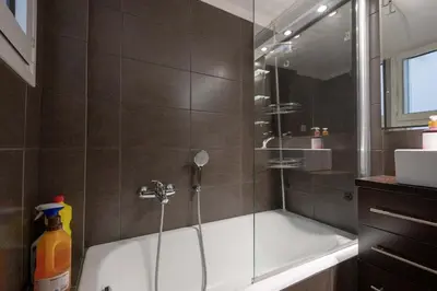 a bathroom with a shower with a bath tub at Gkyzi Warm Classic Home by ΜΡS in Athens