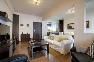 a living room with a white couch and a table at Gkyzi Warm Classic Home by ΜΡS in Athens
