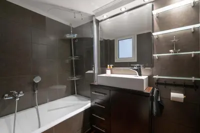 a bathroom with a sink and a tub and a shower at Gkyzi Warm Classic Home by ΜΡS in Athens