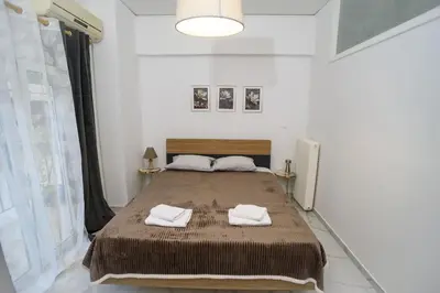 a bedroom with a large bed with two towels on it at The Little Yard Downstairs Apt - Goudi by ΜΡS in Athens