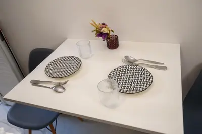 a white table with utensils on top of it at The Little Yard Downstairs Apt - Goudi by ΜΡS in Athens
