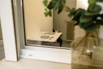 a mirror with a reflection of a table in a room at The Little Yard Downstairs Apt - Goudi by ΜΡS in Athens