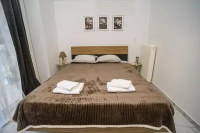 a bedroom with a large bed with two towels on it at The Little Yard Downstairs Apt - Goudi by ΜΡS in Athens