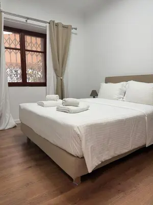a large white bed in a room with a window at Acropolis Traditional Stoney Retreat in Athens