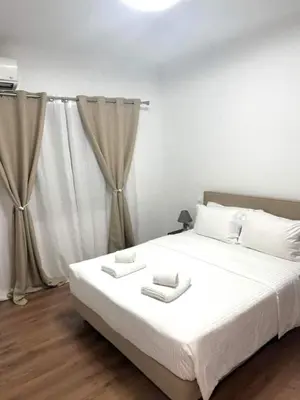 a bedroom with a large bed with white sheets and pillows at Acropolis Traditional Stoney Retreat in Athens
