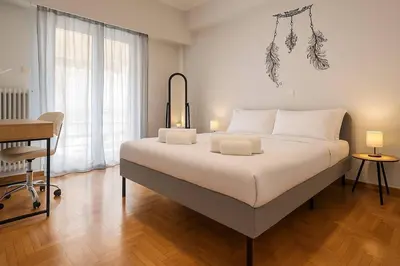 a bedroom with a large white bed with a desk at Cozy Athenian Nest Getaway in Athens