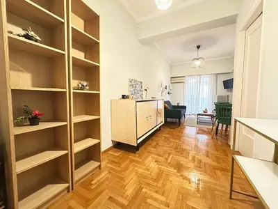 a room with wooden shelves and a living room at Cozy Athenian Nest Getaway in Athens