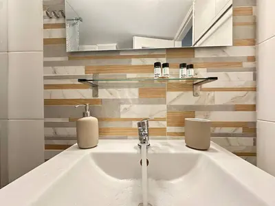 a bathroom with a sink with two soap dispensers at Cozy Athenian Nest Getaway in Athens