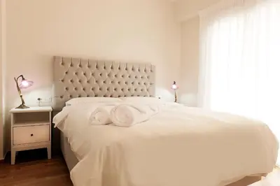 a white bedroom with a large bed with towels on it at Estia Residence Acropolis Apartment in Athens