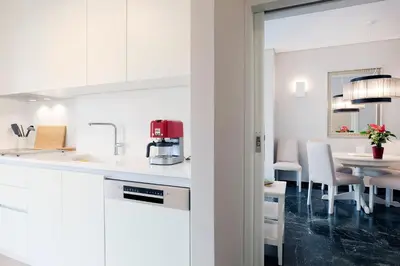 a kitchen with white cabinets and a dining table at Estia Residence Acropolis Apartment in Athens