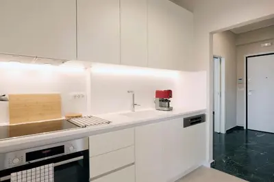 a kitchen with white cabinets and a red appliance at Estia Residence Acropolis Apartment in Athens