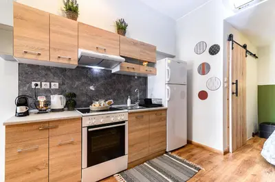 a kitchen with wooden cabinets and a white refrigerator at Studio 35 - Modern & Cozy Studio in Chalandri City Center in Athens