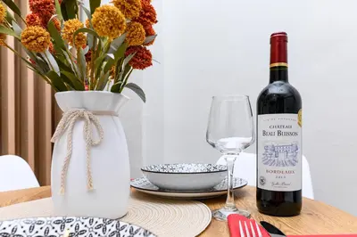 a bottle of wine and a vase with a glass at Studio 35 - Modern & Cozy Studio in Chalandri City Center in Athens