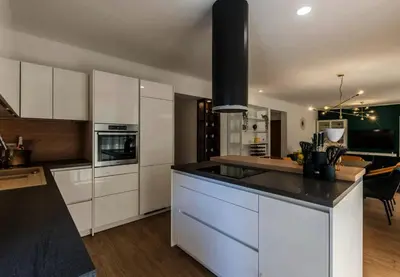 a kitchen with white cabinets and a black counter top at Koukaki Vibe in Athens