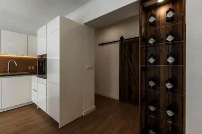 a kitchen with white cabinets and a shelf with shoes at Koukaki Vibe in Athens