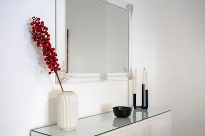 a white vase with a flower in it on a table at Elysian Smyrni - Marble Elegance Retreat in Athens