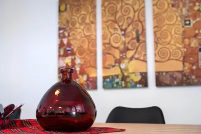 a red glass vase sitting on top of a table at Elysian Smyrni - Marble Elegance Retreat in Athens