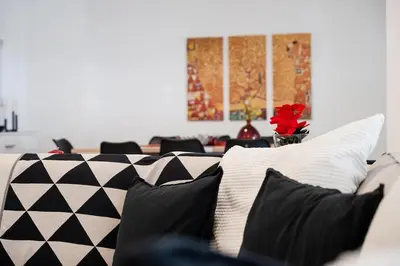 a couch with black and white pillows on it at Elysian Smyrni - Marble Elegance Retreat in Athens