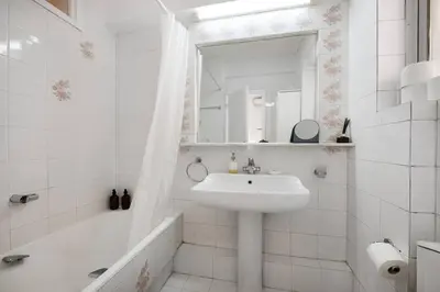 a white bathroom with a sink and a bath tub at Elysian Smyrni - Marble Elegance Retreat in Athens