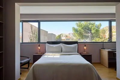 a bedroom with a bed and a large window at Villa Riviera in Vari