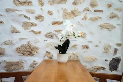 a vase with white flowers sitting on a wooden table at The Marble Retreat in Athens