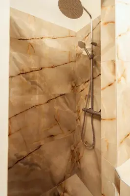 a shower in a bathroom with a stone wall at The Marble Retreat in Athens