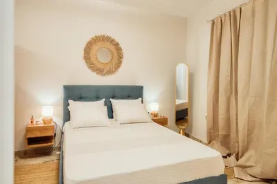 a bedroom with a bed with a blue headboard and a mirror at The Marble Retreat in Athens
