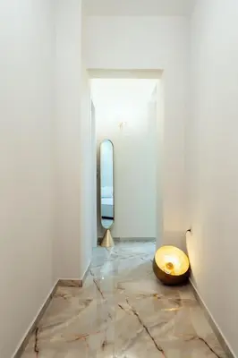 a room with a mirror and a wooden stool at The Marble Retreat in Athens