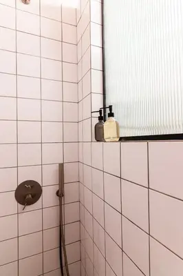 a white tiled bathroom with a shower and a mirror at Fluffy clouds Psiri Athens in Athens