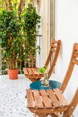 two wooden chairs and a table on a patio at Fluffy clouds Psiri Athens in Athens