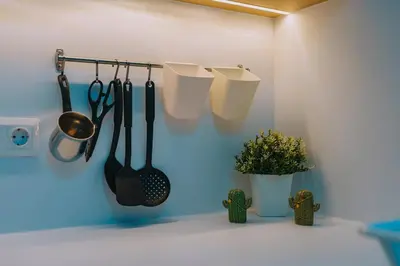 a kitchen with utensils hanging on a wall at Chic and Cozy Apartment in the Heart of Glyfada in Athens