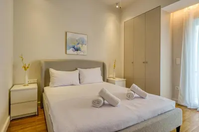 a bedroom with a bed with two pillows on it at Chic and Cozy Apartment in the Heart of Glyfada in Athens