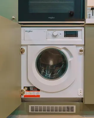 a washing machine with a microwave on top of it at Chic and Cozy Apartment in the Heart of Glyfada in Athens