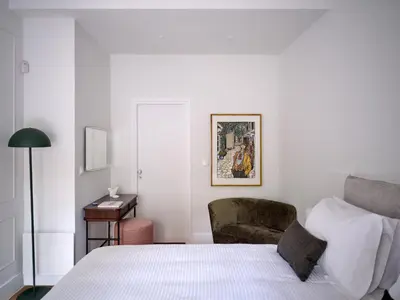 a bedroom with a bed and a chair and a desk at 12ve Plaka, a Chic Apartment in the Heart of Plaka in Athens