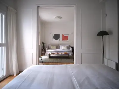 a white bedroom with a bed and a couch at 12ve Plaka, a Chic Apartment in the Heart of Plaka in Athens