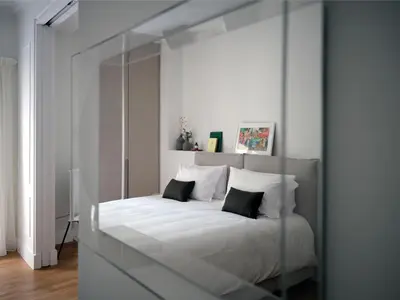 a bedroom with a large white bed with a mirror at 12ve Plaka, a Chic Apartment in the Heart of Plaka in Athens