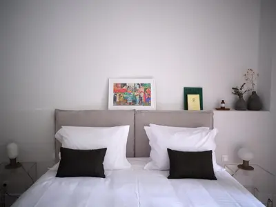 a bedroom with a bed with white sheets and pillows at 12ve Plaka, a Chic Apartment in the Heart of Plaka in Athens