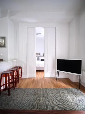 a living room with a television and a table and chairs at 12ve Plaka, a Chic Apartment in the Heart of Plaka in Athens
